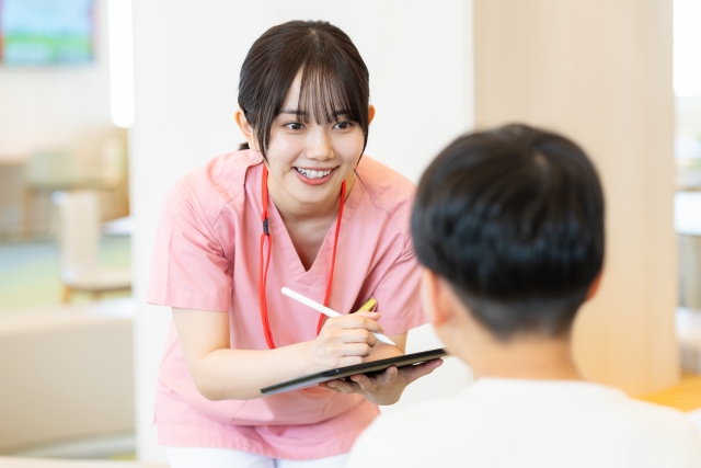 相談者の話を聞きながらメモをとる看護師