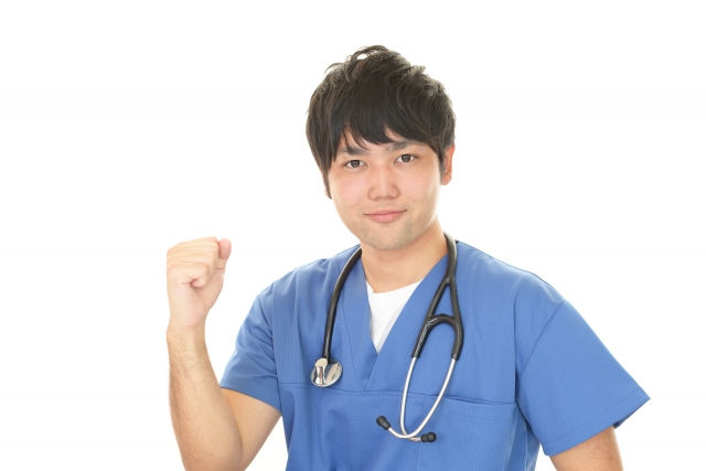 スクラブ姿でガッツポーズをする若手医師