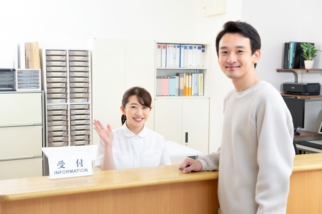 受付カウンターで来院者を迎えるスタッフ